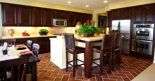 This kitchen has a beautiful rust colored tile floor.